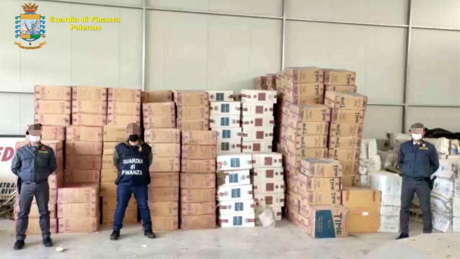 policemen standing in front of very high piles of boxes of cigarettes