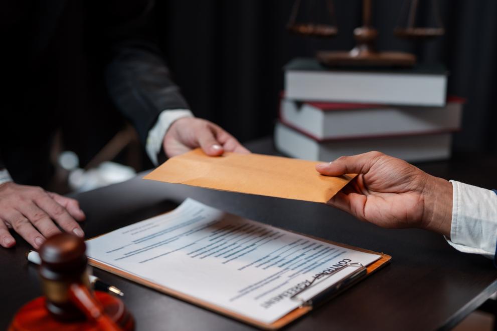 two men handing over an envelope