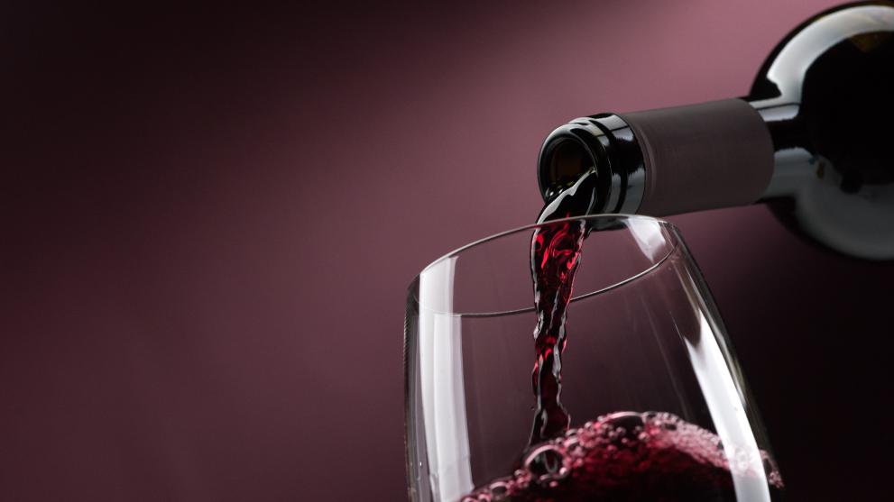 someone pouring wine into a glass