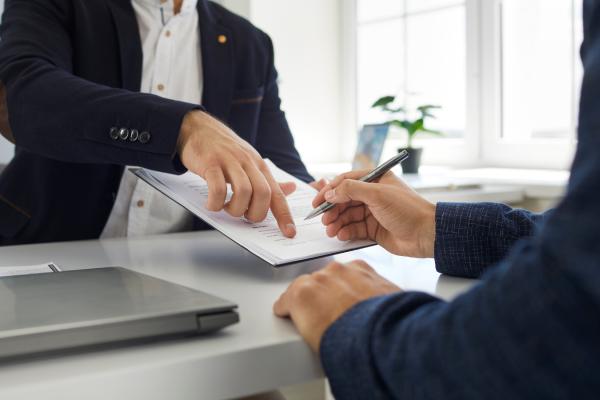 someone showing someone else where to sign