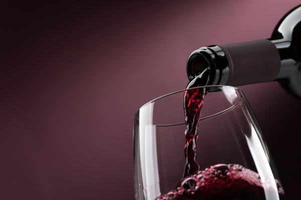 someone pouring wine into a glass